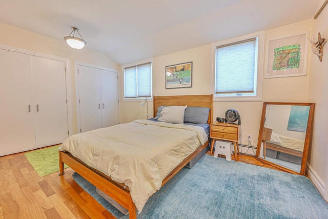 351 Bch 87th St, Rockaway Beach, NY 11693 - bedroom with light wood finished floors, vaulted ceiling, multiple closets, and baseboard heating