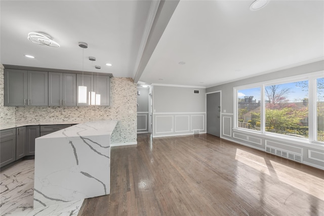 kitchen with light stone counters, decorative light fixtures, gray cabinetry, visible vents, and crown molding