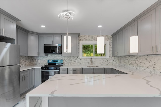 kitchen with gray cabinetry, stainless steel appliances, decorative backsplash, and light stone counters
