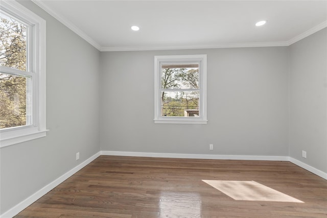 spare room with wood finished floors, crown molding, recessed lighting, and baseboards