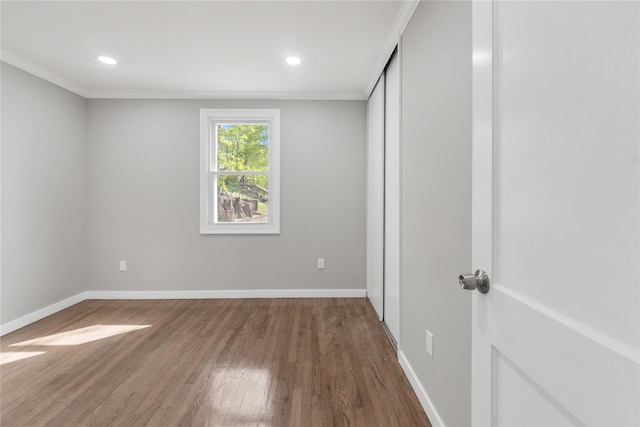 unfurnished bedroom with baseboards, ornamental molding, and wood finished floors
