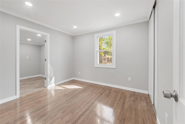 unfurnished bedroom featuring recessed lighting, a closet, baseboards, ornamental molding, and wood finished floors