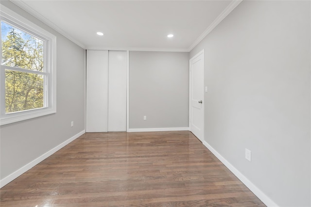 spare room featuring crown molding, recessed lighting, wood finished floors, and baseboards