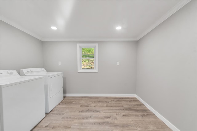 clothes washing area with light wood-style floors, laundry area, crown molding, and independent washer and dryer