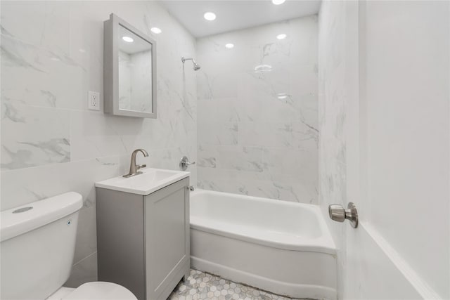 full bath with recessed lighting, tile walls, toilet, vanity, and washtub / shower combination