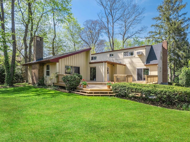 rear view of property featuring a lawn, a chimney, and board and batten siding