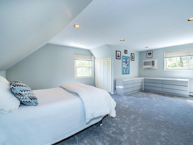 bedroom with lofted ceiling, a wall mounted air conditioner, a closet, recessed lighting, and carpet flooring