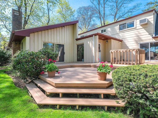 rear view of property featuring a wall mounted air conditioner, a chimney, a deck, and board and batten siding