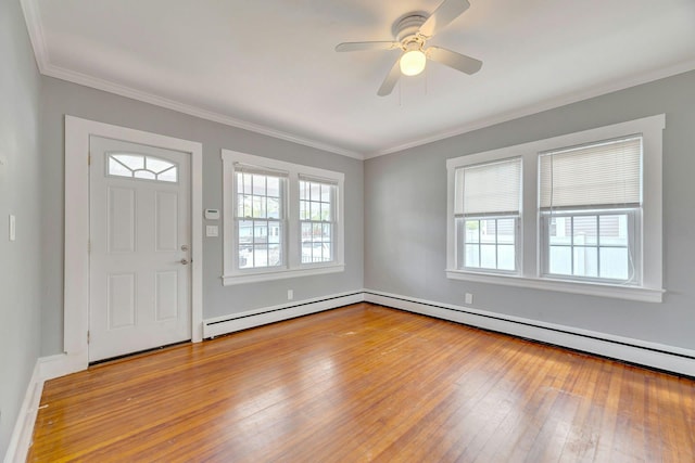 entryway with a baseboard heating unit, wood-type flooring, ceiling fan, crown molding, and baseboards