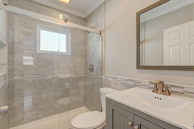 full bathroom featuring a shower stall, tile walls, toilet, vanity, and crown molding