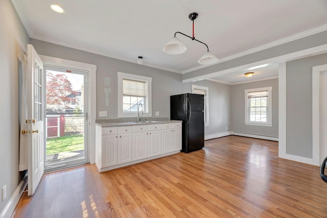 kitchen featuring a baseboard heating unit, a sink, light wood-type flooring, white cabinets, and freestanding refrigerator