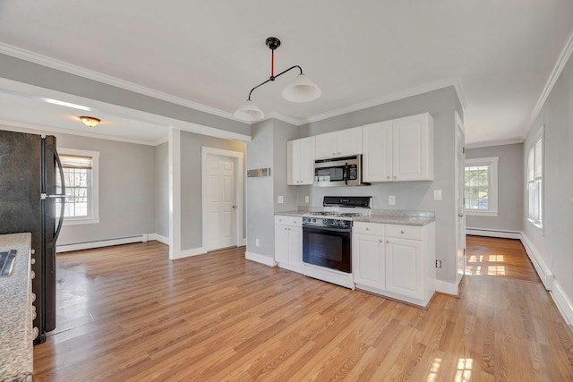 kitchen featuring stainless steel microwave, gas range oven, baseboard heating, freestanding refrigerator, and light wood-type flooring
