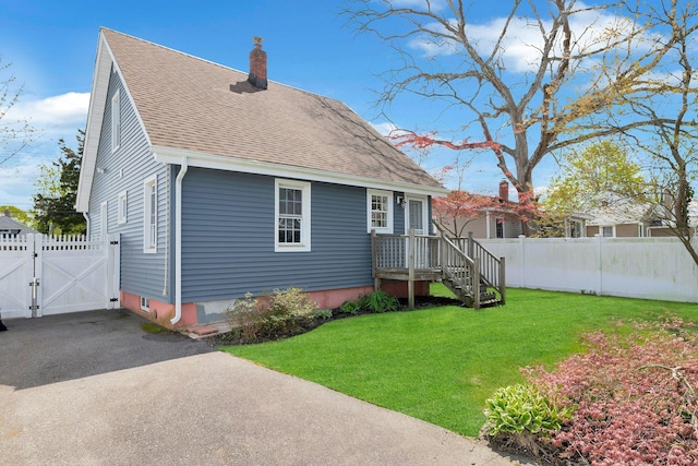 rear view of property with a chimney, fence, a gate, and roof with shingles