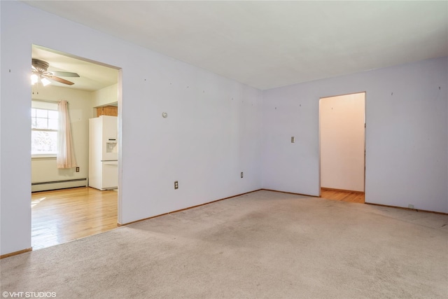 empty room with baseboards, ceiling fan, baseboard heating, and light carpet