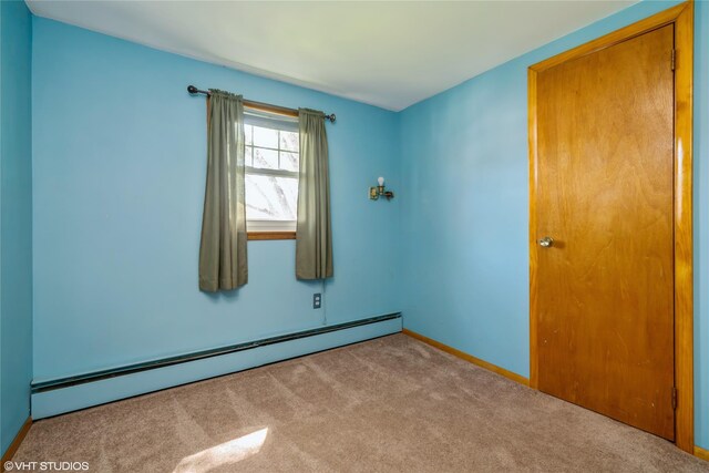 carpeted spare room with baseboards and baseboard heating