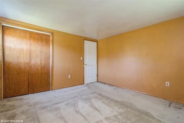 unfurnished bedroom featuring carpet flooring and a closet