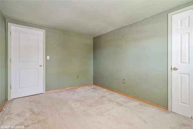 empty room with baseboards and carpet