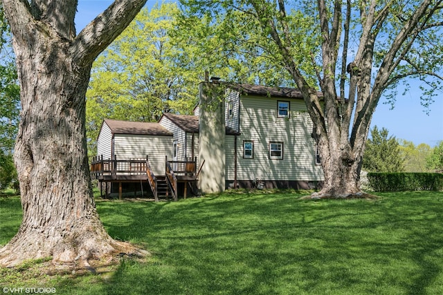 rear view of house featuring a yard and a deck