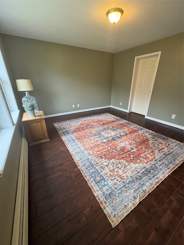 487 Southwoods Dr, Monticello, NY 12701 - empty room featuring a baseboard heating unit, baseboards, and dark wood-type flooring