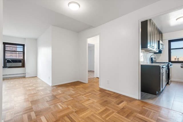 21-36 33rd Rd Unit 7B, Astoria, NY 11106 - kitchen with appliances with stainless steel finishes, a baseboard radiator, cooling unit, light countertops, and baseboards