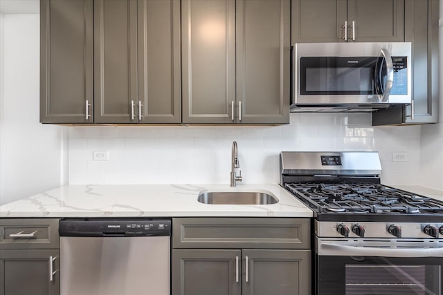 21-36 33rd Rd Unit 7B, Astoria, NY 11106 - kitchen featuring appliances with stainless steel finishes, a sink, gray cabinets, decorative backsplash, and light stone countertops
