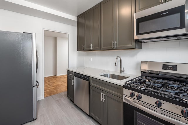 21-36 33rd Rd Unit 7B, Astoria, NY 11106 - kitchen featuring appliances with stainless steel finishes, a sink, tasteful backsplash, and light stone counters