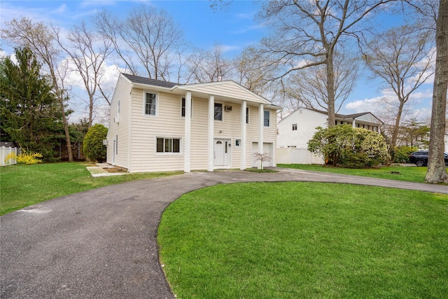 neoclassical / greek revival house with driveway and a front lawn