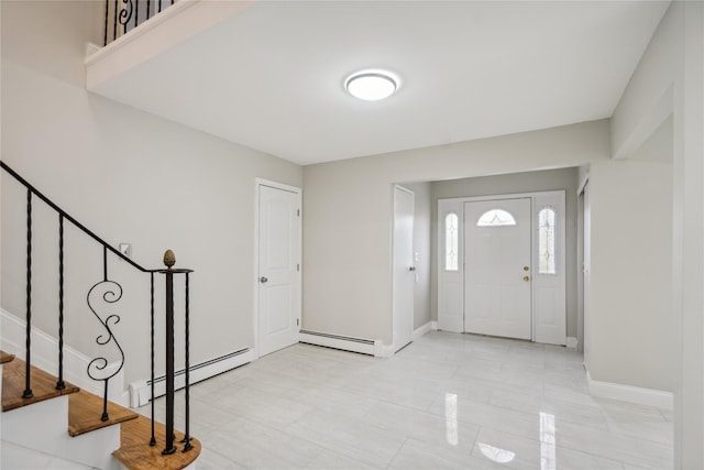 entryway with baseboards, a baseboard heating unit, and stairs