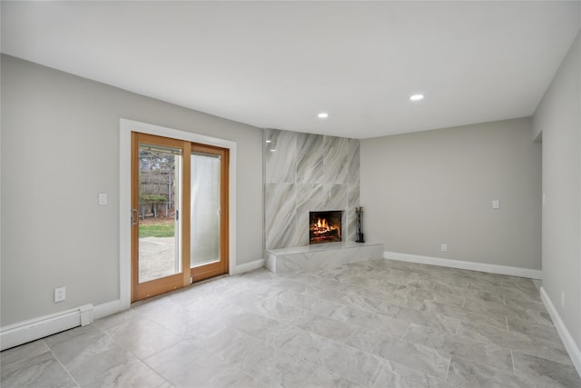 unfurnished living room with recessed lighting, baseboards, a baseboard heating unit, and a premium fireplace