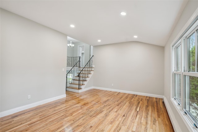 spare room featuring an inviting chandelier, stairs, baseboards, light wood-style floors, and recessed lighting