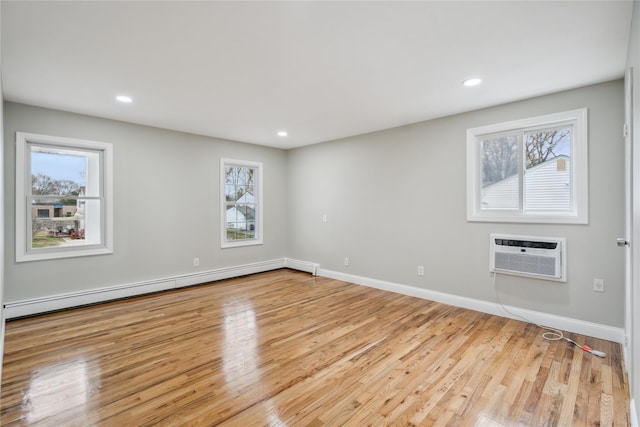 empty room with recessed lighting, a baseboard heating unit, a wall unit AC, and wood finished floors