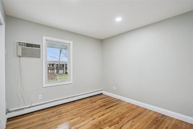 empty room with a wall unit AC, light wood-type flooring, baseboards, a baseboard heating unit, and recessed lighting