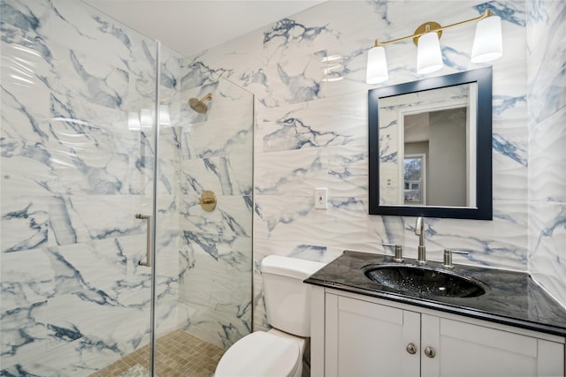 full bathroom with vanity, a marble finish shower, toilet, and tile walls