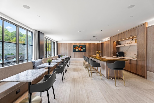 41 Richmondville Ave Unit Duplex 2, Call Listing Agent, CT 06880 - kitchen with wooden walls, modern cabinets, brown cabinets, a kitchen island with sink, and a kitchen breakfast bar
