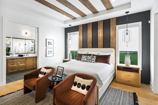 bedroom with light wood-style floors, connected bathroom, recessed lighting, and a sink