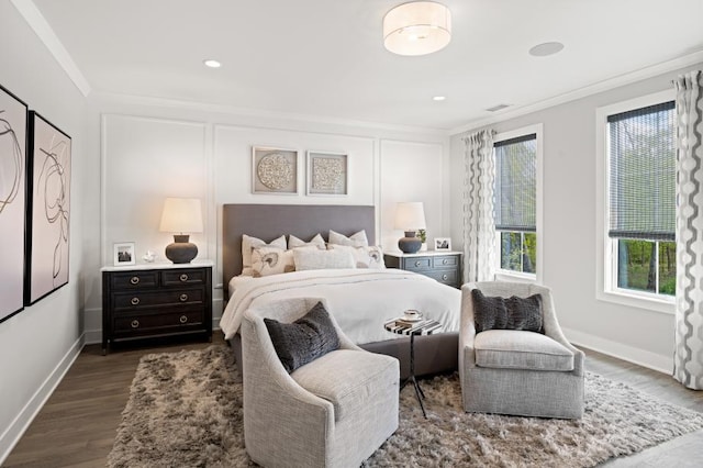 bedroom featuring dark wood-type flooring, visible vents, crown molding, and baseboards