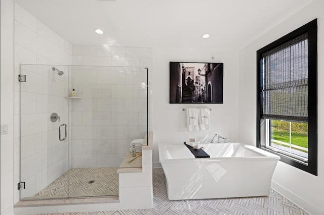full bath featuring a freestanding tub, a shower stall, recessed lighting, and baseboards