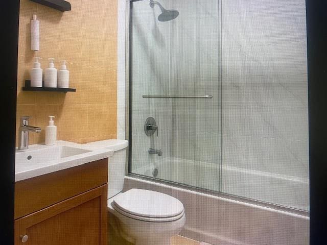 841 Prescott Pl, West Babylon, NY 11704 - bathroom with tile walls, bath / shower combo with glass door, toilet, and vanity