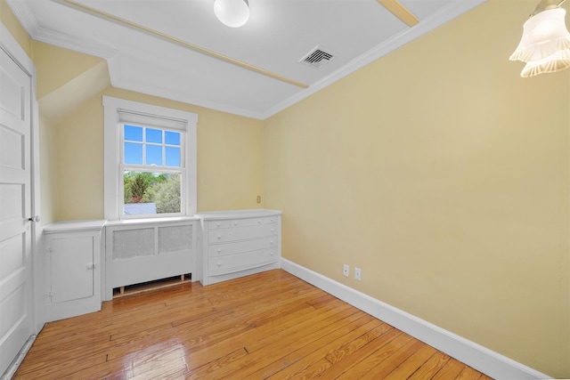interior space with crown molding, baseboards, light wood-type flooring, and visible vents
