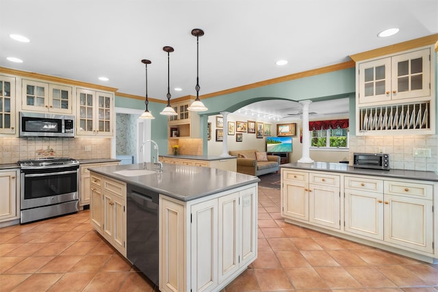 kitchen featuring a sink, decorative columns, light tile patterned floors, and stainless steel appliances