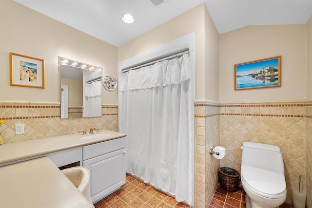 full bath featuring vanity, wainscoting, and tile walls