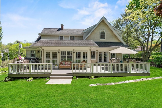 back of property featuring a lawn, french doors, and a deck