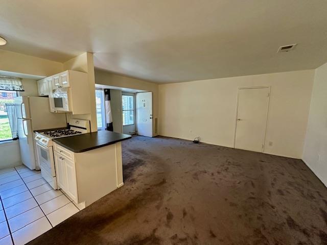 3 Kiowa Ct Unit 3K, Coram, NY 11727 - kitchen featuring dark countertops, visible vents, white cabinetry, and white appliances