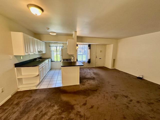 3 Kiowa Ct Unit 3K, Coram, NY 11727 - kitchen with white cabinets, a sink, dark countertops, carpet, and open shelves