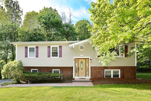 bi-level home with a front lawn and brick siding