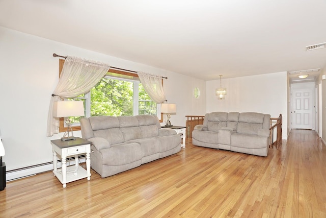living area with a baseboard radiator, wood finished floors, and a chandelier
