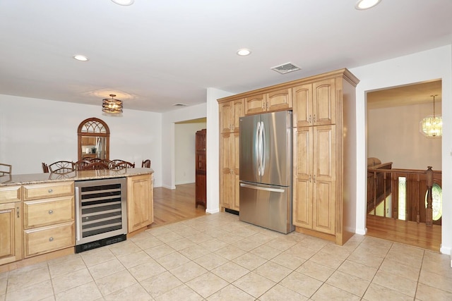 kitchen with freestanding refrigerator, wine cooler, light stone countertops, recessed lighting, and light tile patterned flooring