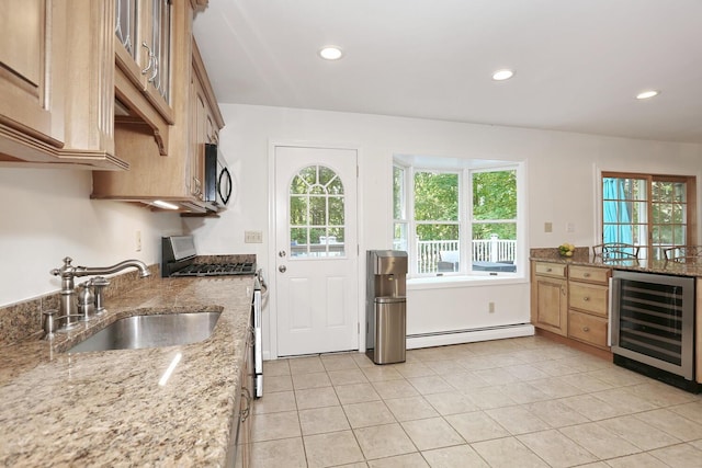 kitchen with beverage cooler, a sink, appliances with stainless steel finishes, a baseboard radiator, and recessed lighting