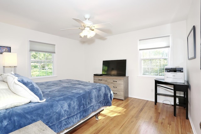 bedroom with light wood-type flooring, baseboards, and a ceiling fan