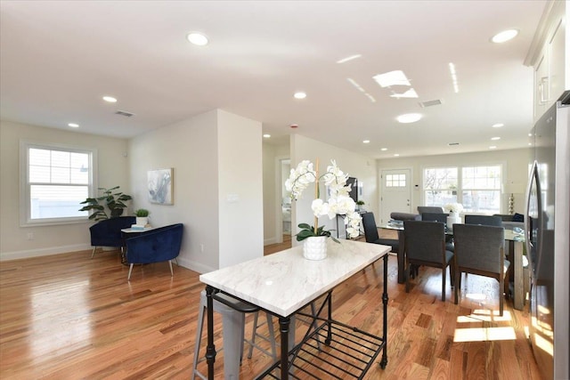 dining room with light wood-style floors, plenty of natural light, and recessed lighting